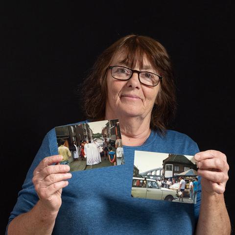 Vrouw toont oude foto's van de wijkkermis van Arsenaal