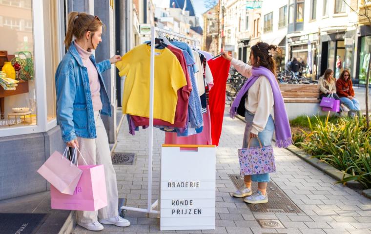 Shoppende dames aan kledingrek