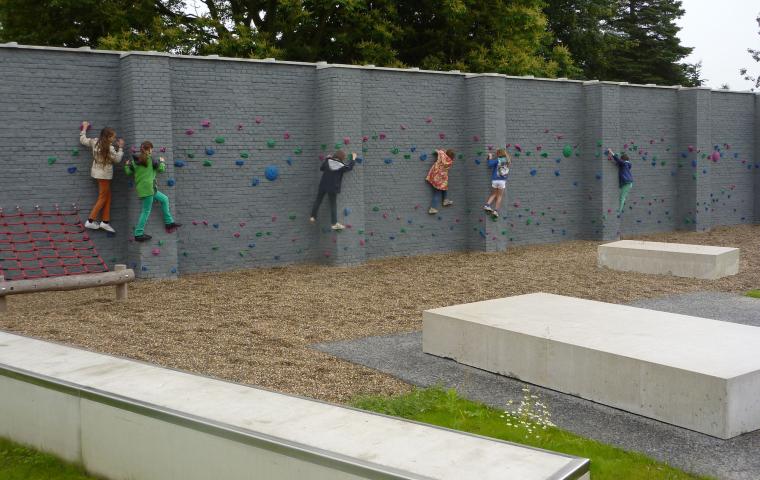 Kinderen klimmen op de klimmuur in het Caputsteenpark in Mechelen.