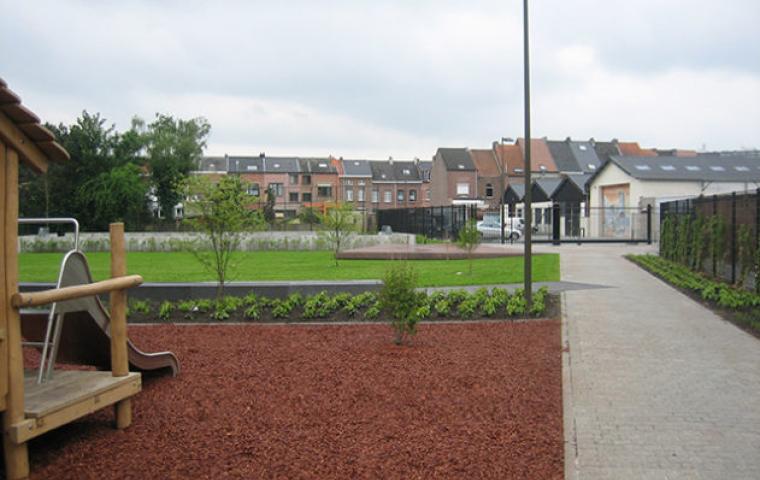 Zicht op het park Donkerlei met speeltuigen en een grasveld.