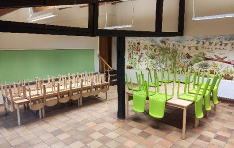 De zaal van de kinderboerderij met tafels en stoelen