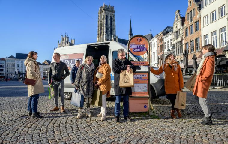 Mensen wachten aan de Shopping Shuttle op de Grote Markt in Mechelen