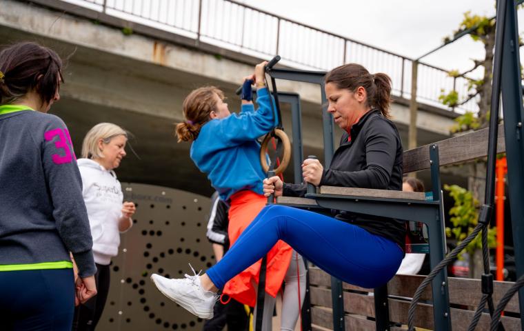 Vrouwen testen de outdoor toestellen uit.
