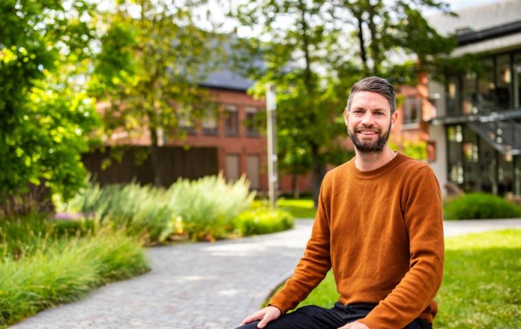 Collega poseert in Sinte-Mettetuin
