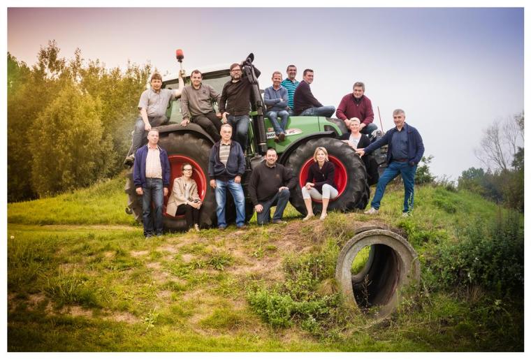 De leden van de land- en tuinbouwraad poseren samen op een tractor.