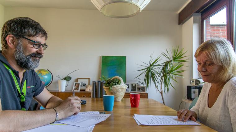 Een energiespecialist zit samen met een inwoner om te kijken naar oplossingen om energie te besparen.