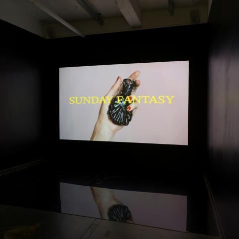 Groot scherm met een hand die een glazen potje vast heeft 