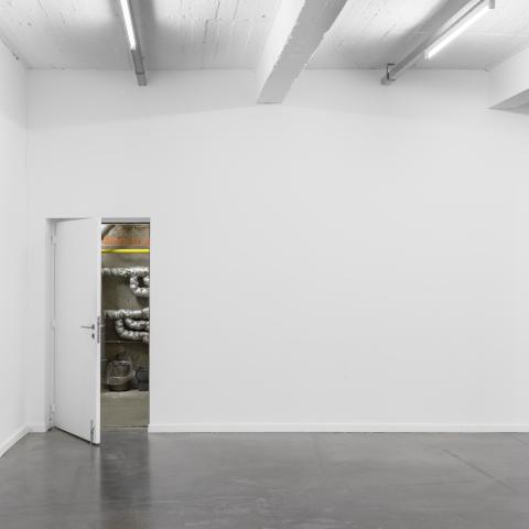 Witte ruimte met één deur die half open staat 