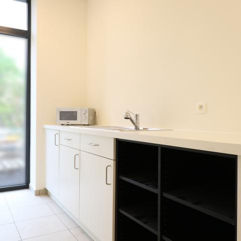 De kitchenette in de vergaderzalen met microgolf, koelkast en wasbak.