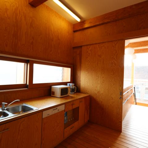 Kleine keuken met microgolf, koffiezet, wasbak en afwasmachine.