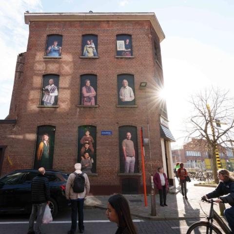 Een hoekhuis in wijk Arsenaal met 9 grote portretten van buurtbewoners