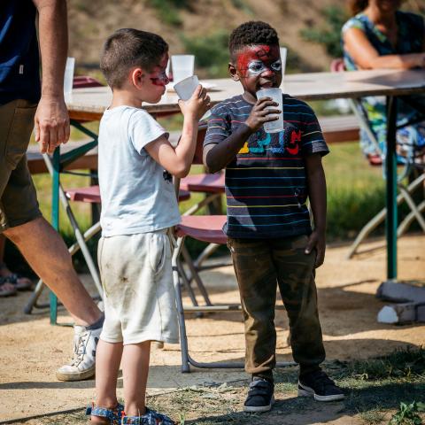 Kinderen drinken van hun drankje tijdens het openingsfeest van 't Hofke