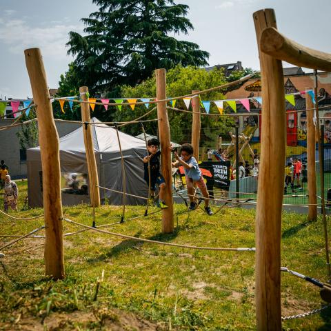 Kinderen spelen op het touwenparcours van de speeltuin.