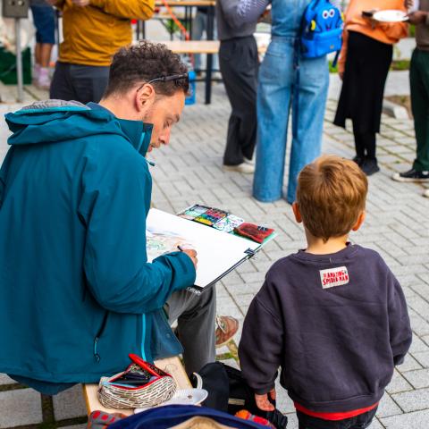 Kunstenaar tekent de buurt tijdens opening van Paardenkerkhofstraat