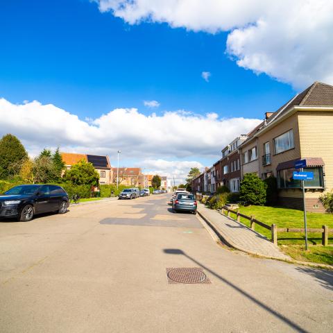 Het brede deel van de Voetbalstraat voor de werken. In het wegdek zitten er verschillende scheuren en putten.