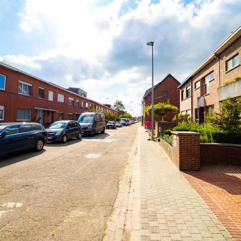 Het smallere deel van de Voetbalstraat voor de werken. In het wegdek zitten er verschillende scheuren en putten. 