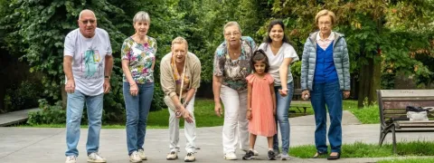 6 ouderen en 1 kind zijn petanque aan het spelen