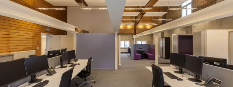 Bureaus, bureaustoelen en computerschermen in een leeg kantoor.